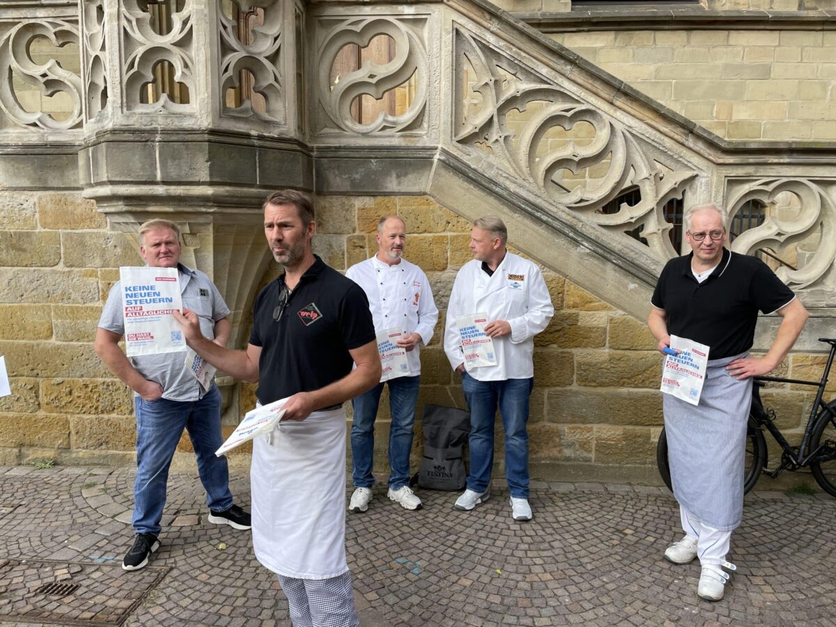 „Keine neuen Steuern auf Alltägliches“: Osnabrücks Bäcker und Fleischer machen gegen Verpackungssteuer mobil Rainer Welp (vorne) ist Obermeister der Bäckerinnung und präsentiert die neuen Brötchentüten. / Foto: Dominik Lapp