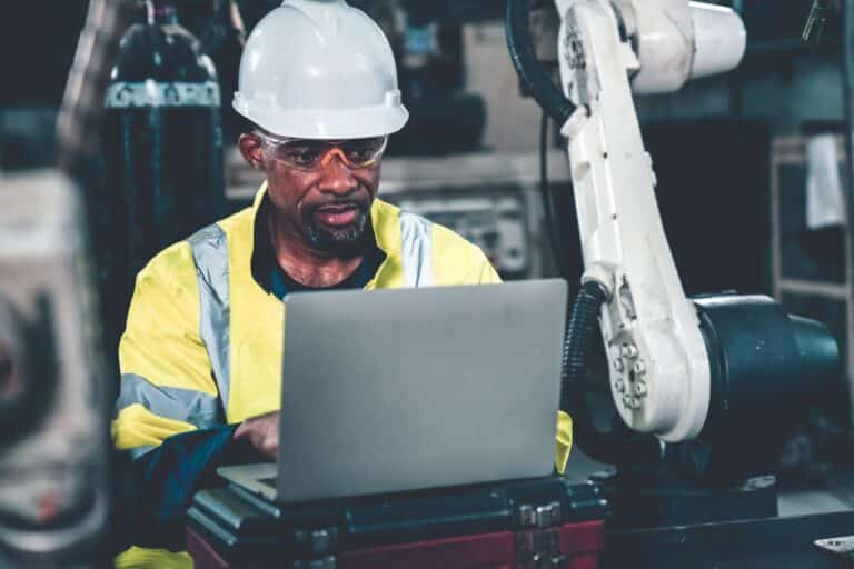 Factory worker working with laptop computer to do adept procedure checklist