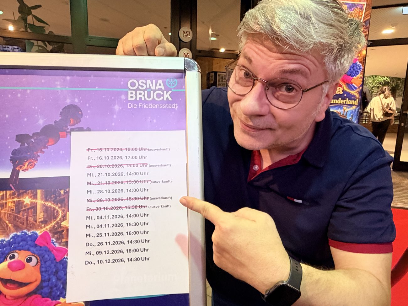 Yogi Eick zeigt auf ein Plakat mit den Vorstellungsterminen von Fabulara