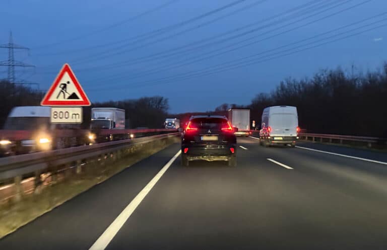 Baustellen-Warnschild mit 800-Meter-Hinweis an einer Autobahn in der Dämmerung