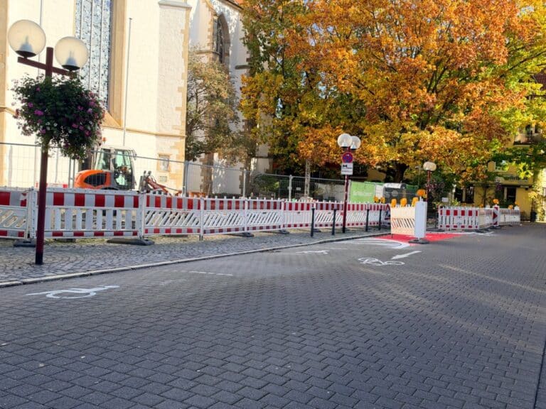 Baustelle mit Absperrgittern in der Osnabrücker Bierstraße neben der Dominikanerkirche, auf der Straße sind Markierungen für Fahrradstellplätze zu sehen.