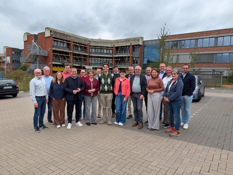 Mitglieder der SPD- und UWG-Gruppe im Kreistag beim Gruppenfoto auf einem gepflasterten Platz vor einem Backsteingebäude