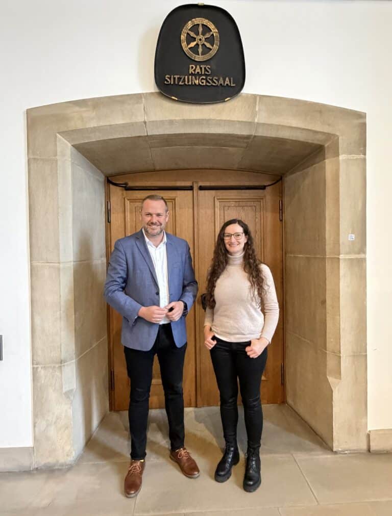 Robert Alferink und Lisa-Marie Markmann vor der Tür zum Ratssitzungssaal im Rathaus Osnabrück