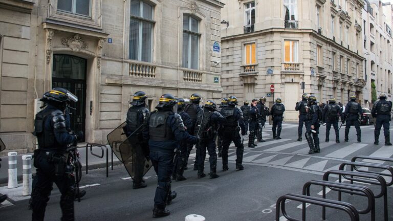 Französische Bereitschaftspolizisten mit Helmen und Schilden auf einer Straße in Paris