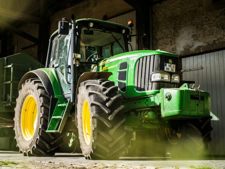 Grüner Traktor vor einer Scheune