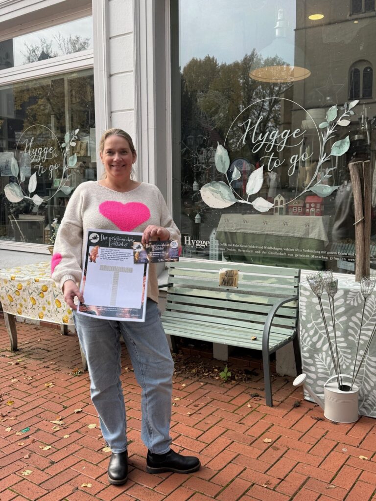 Frau mit Rallye-Plakat vor dem Geschäft Hygge to go in Melle