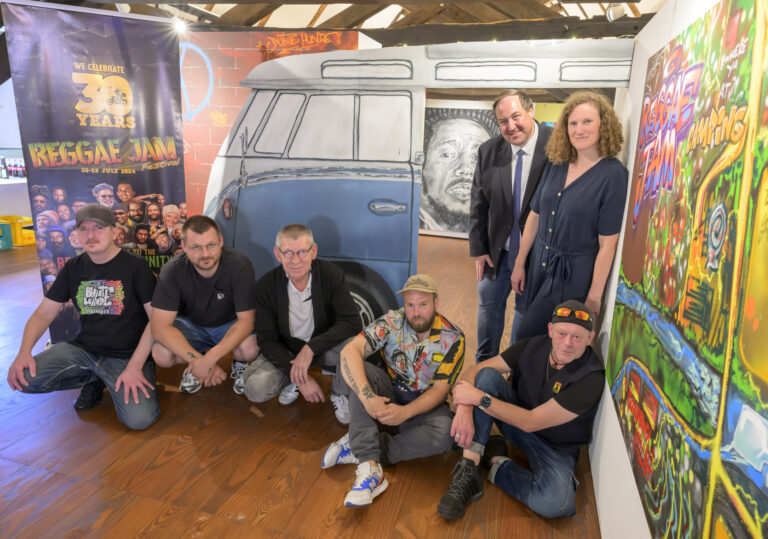 Bildunterschrift zum Titelbild: Bunt und kreativ präsentieren die "Bunten Hunde" das Thema 30 Jahre Reggae Jam im Museum im Kloster. Sitzend von links: Max „Optick“ Fuhrmann und Alexander „Miaskoh“ Cordes (beide Bunte Hunde), Bernard Wolinski (Museum im Kloster), Christian „Das Wort“ Aretz (Bunte Hunde) und Reggae-Jam-Gründer Bernd „Sheriff“ Lagemann; stehend: Kreistagsabgeordneter Jörg Brüwer und Museumsleiterin Katharina Pfaff. Es fehlt das Bunte-Hunde-Mitglied Marcel „Senf“ Ostendorf. Foto: Landkreis Osnabrück / Hermann Pentermann