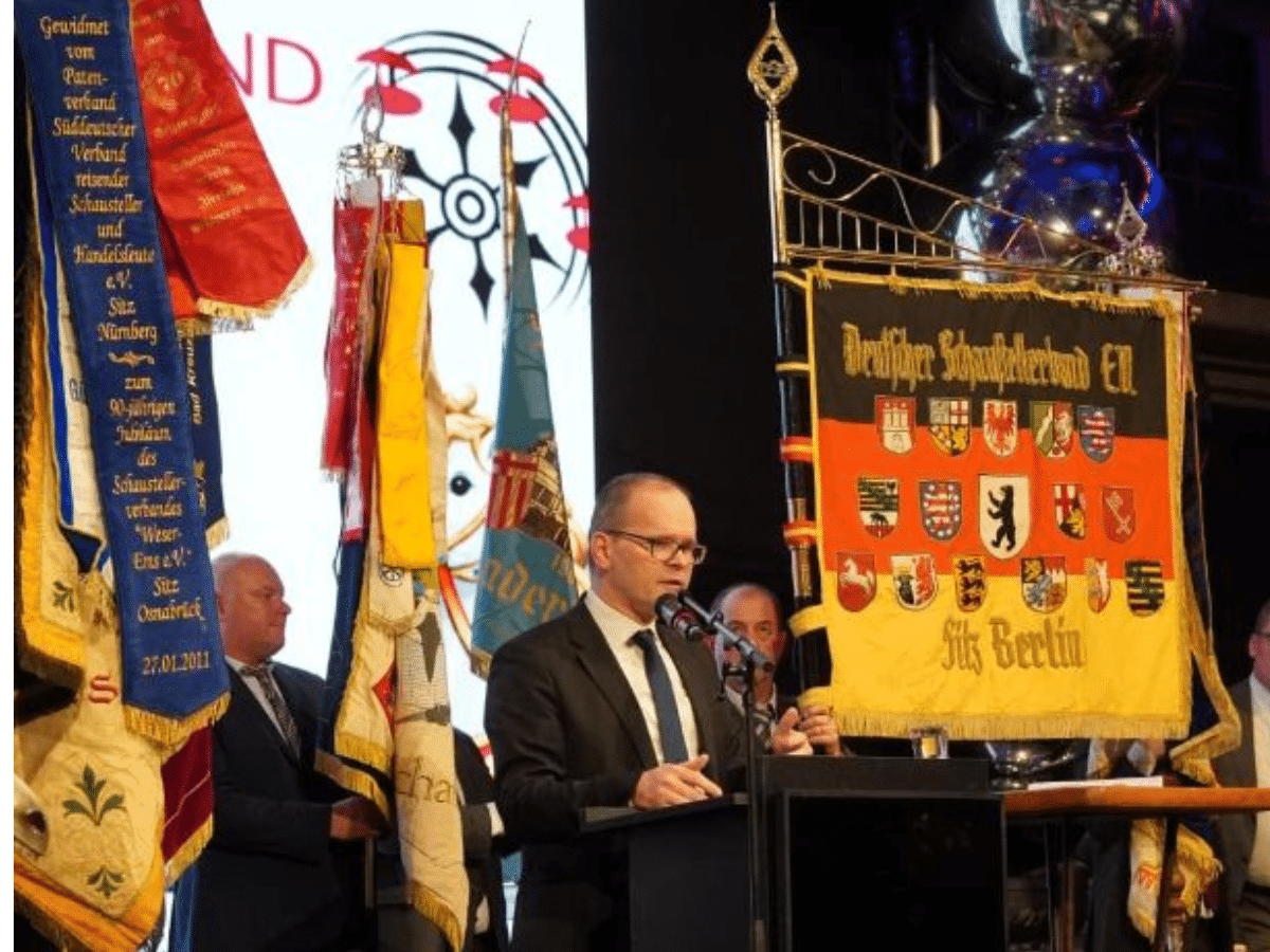 Der niedersächsische Wirtschaftsminister Grant Hendrik Tonne bei seiner Festrede ( im Hintergrund das Fahnenmeer der auswärtigen Schaustellerverbände). / Foto: Schaustellerverband Wester-Ems e.V.