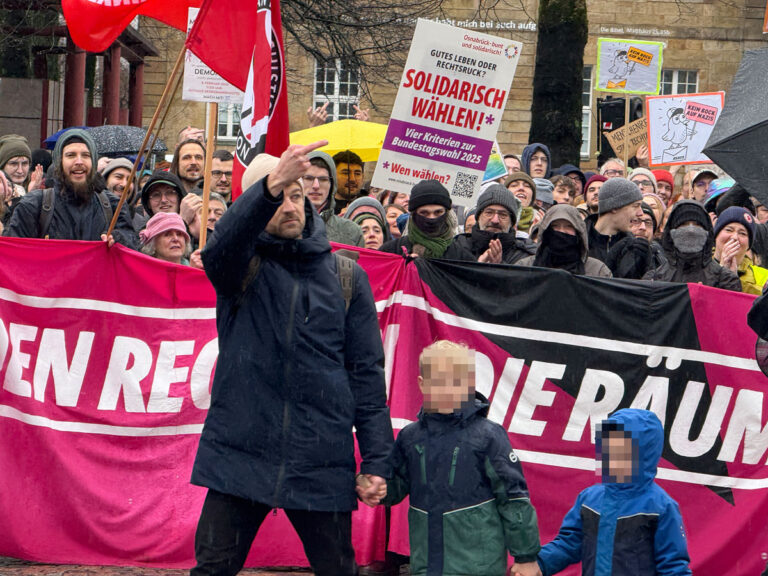 AfD-Gegendemonstrant mit Mittelfinger und Kindern