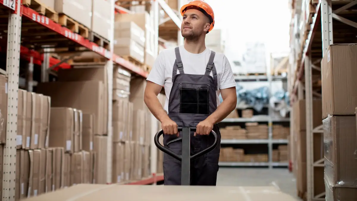 Lagerarbeiter mit einer Palette auf einem Hubwagen