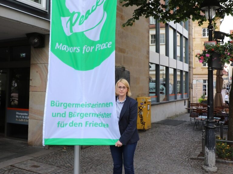 Osnabrücks Oberbürgermeisterin Katharina Pötter mit der Flagge der Mayors of Peace. / Foto: Constantin Binder