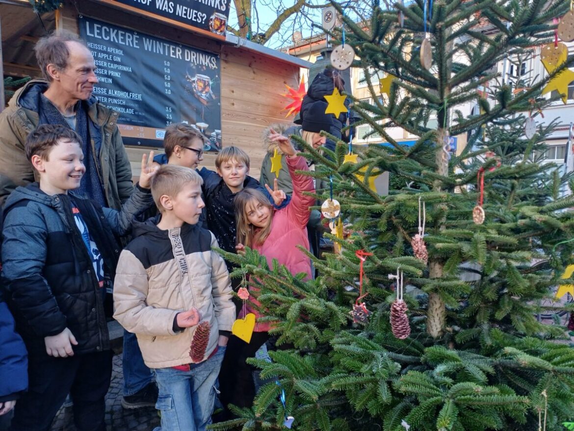 Das macht Freude: Zusammen mit ihren Lehrerinnen nahmen auch diese Schülerinnen und Schüler an der Weihnachtsbaum-Schmückaktion teil. / Foto: Stadt Melle