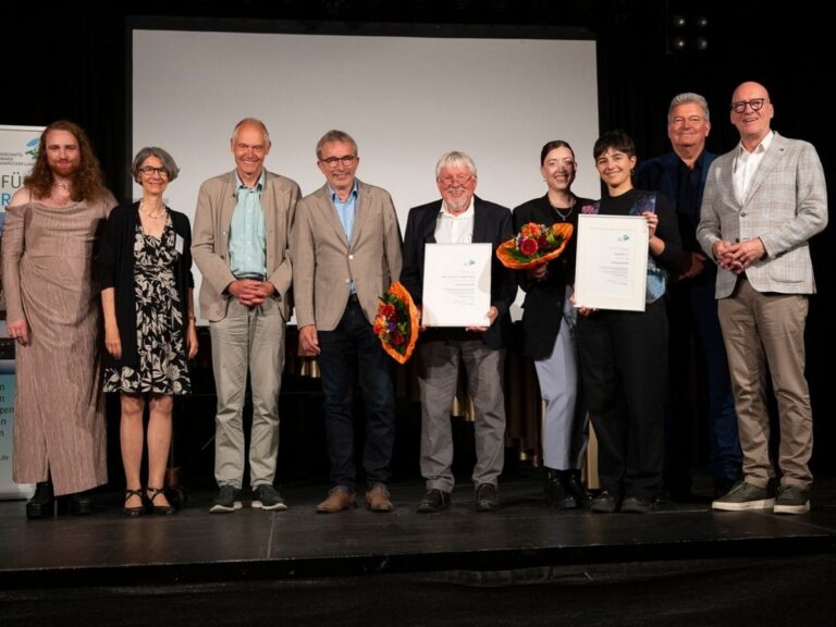 Zum Abschluss des Landschaftstages 2025 zeigten sich auf der Bühne nur strahlende Gesichter: (vlnr) Madou Klaes (Queer-Beirat der Stadt Osnabrück), Dr. Susanne Tauss (LVO-Geschäftsführerin), Dr. Hermann Queckenstedt (LVO-Vorstand), Norbert Niedernostheide (Direktor Museum am Schölerberg), Professor em. Dr. Herbert Zucchi, Lutz und Adri (QueerOS e. V.), Matthias Selle (Kreisrat und stellv. LVO-Vorsitzender) und Wolfgang Beckermann (Erster Stadtrat und LVO-Vorsitzender) / Foto: Angela von Brill