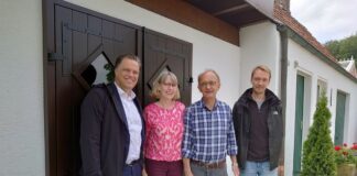 Mit dem Silo für die Holzhackschnitzel im Hintergrund: (von links) Stadtbaurat Thimo Weitemeier mit Maria, Ansgar und Christoph Budke. / Foto: Simon Vonstein