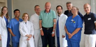 Aktuelle Informationen: Klinikum Osnabrück GmbH Logo 03. Juli 2025, Pressemitteilung Klinikum: Ehemaliger Schüchtermann-Chefarzt bedankt sich für hervorragende Behandlung Dank und Anerkennung mit der höchsten fachlichen Expertise: Prof. Dr. Henning Warnecke, von 1993 bis 2020 Chefarzt der Herzchirurgie in der Schüchtermann-Klinik in Bad Rothenfelde, attestiert dem Klinikum Osnabrück ein besonders hohes Leistungsvermögen in der Schlaganfallversorgung. Warnecke hat davon jetzt selbst profitiert: Wie er schildert, wurde bei ihm vom Team der Stroke Unit, also der Spezialeinheit für Schlaganfallbehandlungen, mit einem speziellen Verfahren eine Gefäßverengung in einer Hirnarterie beseitigt, die ohne diese Behandlung zu einer Lähmung der linken Körperhälfte hätte führen können. Bei dem hochanspruchsvollen Eingriff wurde ein Gefäß im rechten Gehirn mit einem durch die Leiste eingeführten Katheter erst gedehnt und dann ein Stent eingesetzt. Wie Warnecke berichtet, sei er dabei „am wenigsten“ aufgeregt gewesen und habe sich bei den routiniert vorgehenden Behandlern in besten Händen gefühlt. Dem Team aus Neurologie, Radiologie, Anästhesie und Neuroradiologie bescheinigte er ein „wunderbares Zusammenspiel“, gleichsam sei die pflegerische Versorgung „absolut makellos“ gewesen. Warnecke wird seit 2021 vom Schlaganfallspezialisten Prof. Dr. Rainer Dziewas im Klinikum behandelt, nachdem sich bei ihm in dem Jahr und dann 2023 erneut Symptome eingestellt hatten, die auf eine solche Erkrankung hindeuten. Nachdem jetzt wieder Bewegungs- und Greifstörungen bei ihm aufgetreten seien, so Warnecke, habe er sich bei Dziewas gemeldet und sei dann rasch in der von dem Chefarzt geleiteten Klinik für Neurologie aufgenommen worden. Mit den differenzierten Methoden zur Bildgebung, die in dem Haus auf dem Finkenhügel zur Verfügung stehen, sei dann nachgewiesen worden, dass die Symptome von der Verengung eines Hirnblutgefäßes ausgelöst wurden. Wie Dziewas und Florian Krauß, Oberarzt für interventionelle Neuroradiologie, erklären, können sich derart stark verengte Gefäße im Krankheitsverlauf vollständig verschließen. So ein Ereignis führt dann zum Ausfall der Durchblutung in einer größeren Hirnregion und geht häufig mit ausgeprägten Beschwerden einher. Nach den Angaben von Dziewas werden intrakranielle Stenosen, wie der Fachbegriff für solche Gefäßverengungen lautet, in den meisten Fällen mit Medikamenten behandelt. Das Dehnen von Gefäßen und das Einsetzen von Stents komme nicht bei allen Erkrankten infrage, sei aber bei Warnecke die bestmögliche Therapieoption gewesen. Wie der Neuroradiologe Krauß betont, erforderte es höchste Präzision, um wie bei Warnecke ein nur wenig mehr als einen Millimeter dickes Gefäß zu dehnen und dann ein Implantat einzusetzen, welches das Gewebe stützt und offenhält. Der jetzt im Klinikum behandelte Warnecke ist, wie er berichtet, aus der eigenen Praxis als Chef der Herzchirurgie in Bad Rothenfelde damit vertraut, dass auf dem Finkenhügel mit dem Verfahren der interventionellen Radiologie gearbeitet wird. Es sei vor etwa 15 Jahren am Klinikum Osnabrück vom Neuroradiologen Stephan Lowens eingeführt und in einem Vortrag dann auch in der Schüchtermann-Klinik vorgestellt worden. Warnecke berichtete, dass er in der Folge immer wieder Erkrankte zur Behandlung an Lowens und sein Team weitergeleitet habe. Warnecke hat in seiner Laufbahn als Herzchirurg über 12.000 Eingriffe am offenen Herzen selbst ausgeführt und war für über 100.000 Operationen verantwortlich. In die Behandlung von Warnecke war ein interdisziplinäres Team von Ärztinnen und Ärzten sowie speziell geschulten Pflegekräften beteiligt, so unter anderem die Radiologie-Assistenzärztin Eva Wollny, die Stroke-Unit-Oberärztin Dr. Sarah Strickmann, Anästhesie-Chefarzt PD Dr. Peter Teschendorf und die Pflegekräfte Cornelia Rohe-Homme sowie Robin J. Rodriguez. Warnecke war so eingenommen, dass er sich nur Stunden nach dem Eingriff erst per Telefon an Dr. E.h. Fritz Brickwedde, den Aufsichtsratsvorsitzenden des Klinikums, wandte, um am Tag danach in einer Runde mit ihm dem ganzen Behandler-Team zu den hervorragenden Leistungen zu gratulierten. Warnecke und Brickwedde, der dem Aufsichtsrat des Klinikums bereits seit 19 Jahren angehört, davon neun als Vorsitzender, sind befreundet. Zu der pflegerischen Versorgung meinte der 72-jährige Warnecke, dass sich Erkrankte im Klinikum quasi wie ein König oder eine Königin fühlen könnten. „Wenn man königlich behandelt werden möchte, gehört es nach meiner Meinung aber auch dazu, dass man sich anderen gegenüber auch selbst so benimmt“, meinte Warnecke. Bild: Anerkennung für perfekte Versorgung (v.l.): Radiologie-Assistenzärztin Eva Wollny, Pfleger Robin J. Rodriguez, Stroke-Unit-Oberärztin Dr. Sarah Strickmann, Anästhesie-Chefarzt PD Dr. Peter Teschendorf, Patient Prof. Dr. Henning Warnecke, Radiologie-Oberarzt Florian Krauß, Aufsichtsratsvorsitzender Dr. E.h. Fritz Brickwedde, Pflegerin Cornelia Rohe-Homme, Neurologie-Chefarzt Prof. Dr. Rainer Dziewas. / Foto: Jens Lintel
