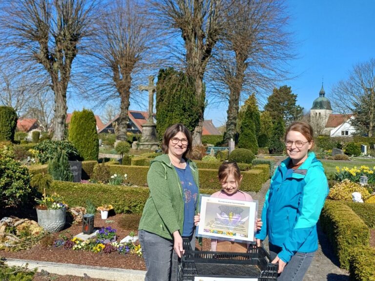 Symbolischer Auftakt der Blumenzwiebelretter-Aktion auf dem Friedhof in Riemsloh mit der Vorsitzenden des Imkervereins Melle, Silke Meier (links), Imkerin Svenja Rasch (rechts) und ihrer Tochter Hannah. Foto: Stadt Melle