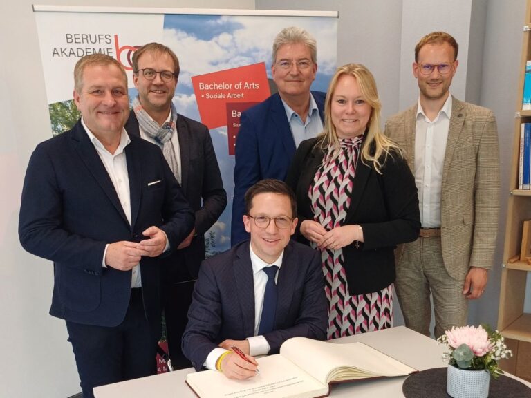 Zur Erinnerung an seinen Besuch in der Berufsakademie trug sich Minister Falko Mohrs (sitzend) in das Goldene Buch der Stadt Melle ein, umgeben von Guido Pott, Joachim Martin, Matthias Selle, Jutta Dettmann und Dominik Braun (von links).