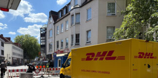 DHL-Fahrzeug vor Straßensperre Maiwoche