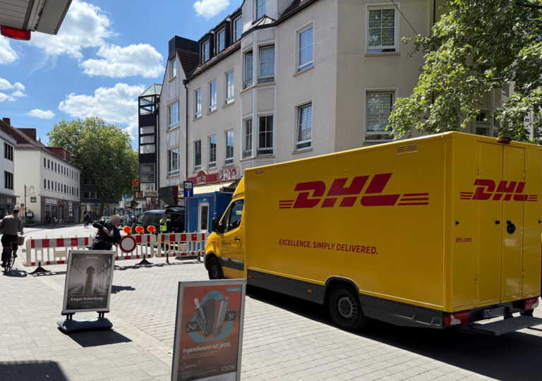 DHL-Fahrzeug vor Straßensperre Maiwoche