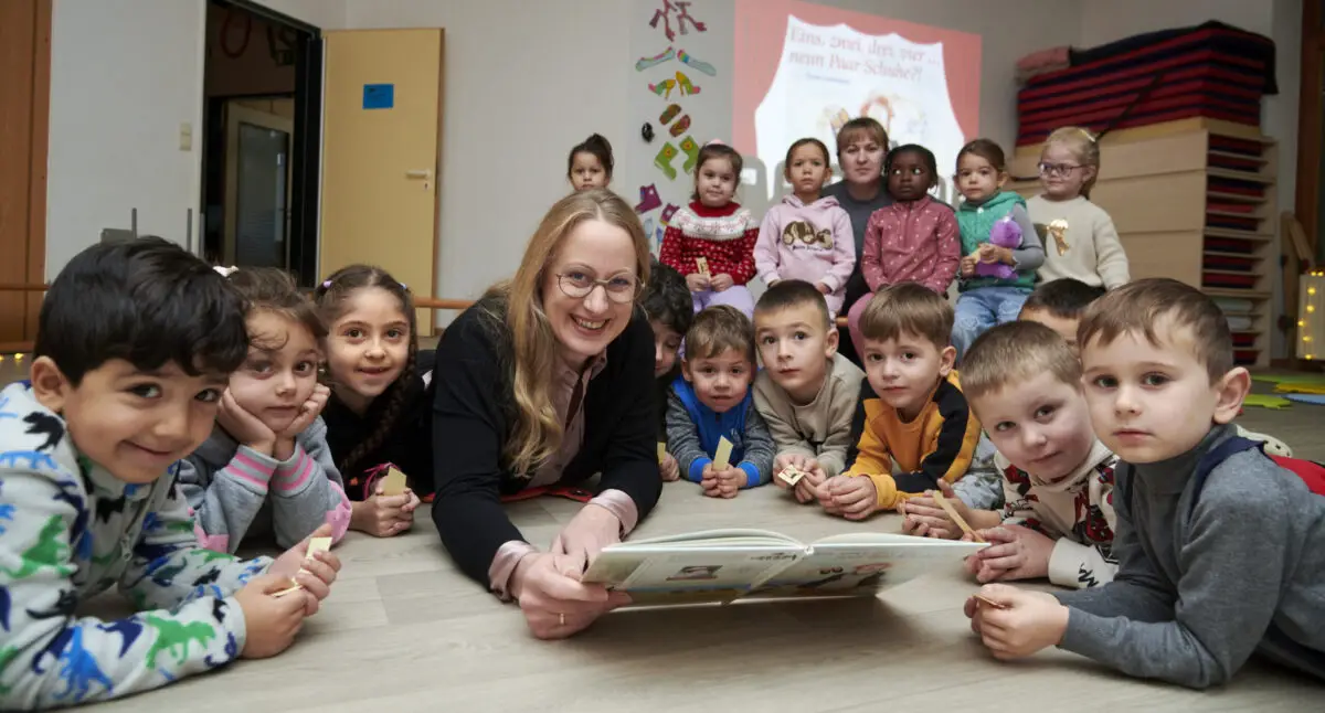 Aufmerksame kleine Zuhörerinnen und Zuhörer hatte Landrätin Anna Kebschull, als sie jetzt in der Kita Kunterbunt aus dem Buch „Eins, zwei, drei, vier…neun Paar Schuhe?!“ vorlas. / Foto: Landkreis Osnabrück, Henning Müller-Detert