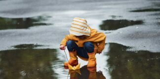 Kind spielt im Regen