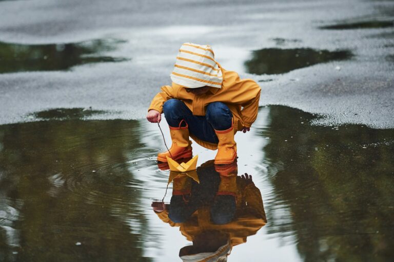 Kind spielt im Regen