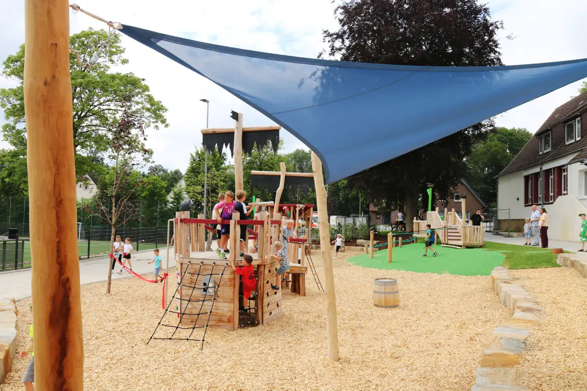 Spielspaß mit Piratenflair: Neuer Kommunikationsplatz an der Grundschule am Harderberg freigegeben Herzstück der Spielfläche ist ein großes „Piratenschiff“ mit jeder Menge Spiel- und Klettermöglichkeiten.