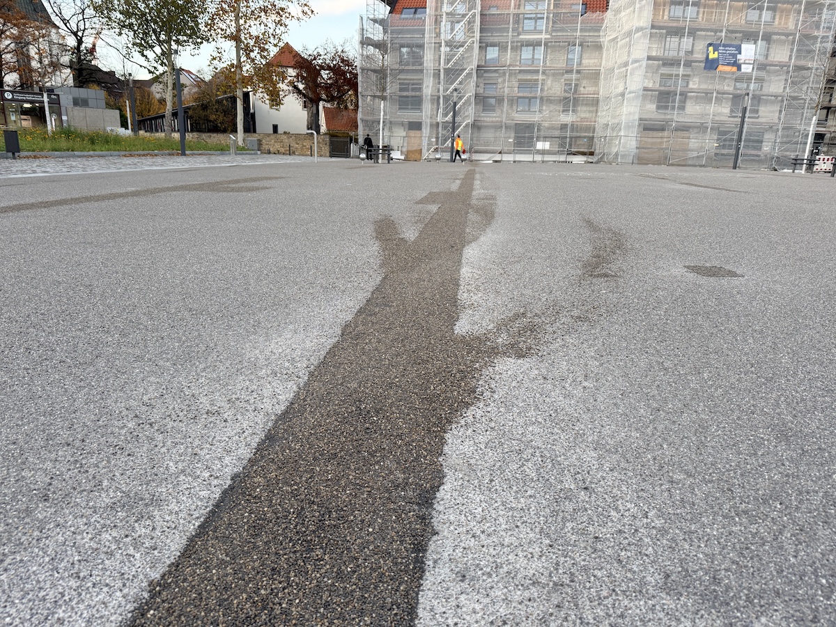 Die "Fachfirma" versucht seit dem Sommer eine einheitliche Oberfläche am Ledenhof herzustellen – die jetzt dunklen Stellen sollen bald die gleiche Farbe annehmen, wie der Rest des Platzes