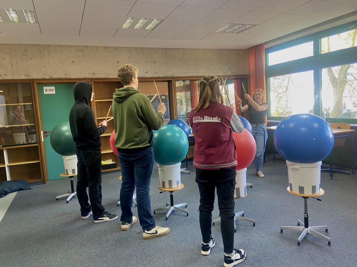 Hörgeschädigte Schüler trommeln und erlernen eine Choreografie.