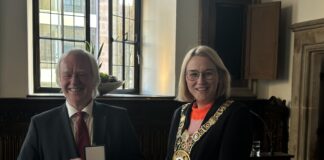 Franz Haverkamp mit dem Bundesverdienstkreuz (links) neben Katharina Pötter mit Verleihungsurkunde (rechts).