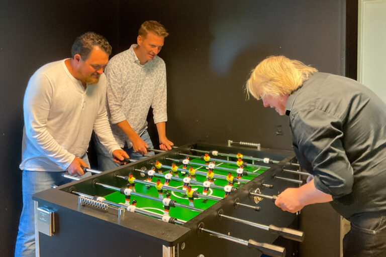 Alex Braun und Rudolf Stromann (von links) von der IPW spielen am Kickertisch gegen Jugendpfleger Jürgen Abeln. / Foto: Gemeinde Wallenhorst