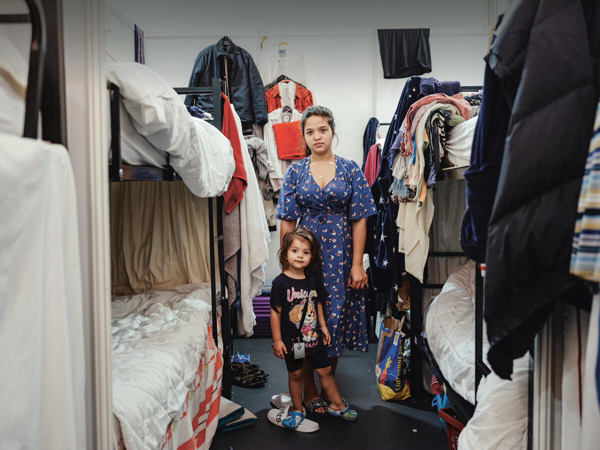 Einblicke in das Aufwachsen auf engstem Raum: Ein Mädchen mit ihrer älteren Schwester in einer Geflüchtetenunterkunft – eine der eindrücklichsten Aufnahmen der Ausstellung „Kein Ort für Kinder!“ von Terre des Hommes. Foto: Max Avdeev