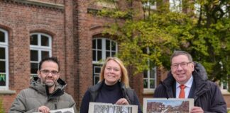 Vor der Kulisse der Grönenbergschule in Melle-Mitte präsentieren (von links) Uwe Plaß, Jutta Dettmann und Jürgen Krämer den Bildkalender „Historische Ansichten aus Melle 2025“, der ab sofort im Handel erhältlich ist. / Foto: Niels Wagner