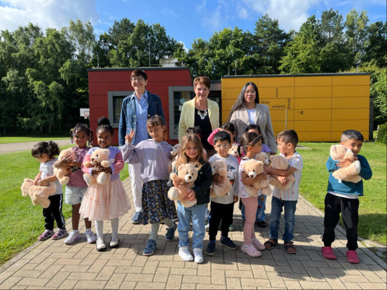 Von hinten links: Heike Walter und Ulrike Burghardt (Bürgerstiftung Osnabrück) übergeben an Ha Mi Vu (Fachbereichsleiterin Aufnahme und Soziales am Standort Osnabrück) und an die Kinder der Landesaufnahmebehörde die Teddybären. / Foto: Bürgerstiftung