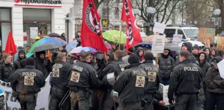 Bereitschaftspolizisten gegen Demonstrierende unter Antifa-Flagge