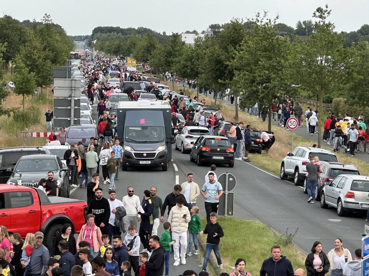 Der Bus mit CR7 und der Nationalmannschaft ist schon lange unterwegs in Richtung Gütersloh, doch die portugiesischen Fans feiern auf der Zufahrt zum FMO einfach weiter