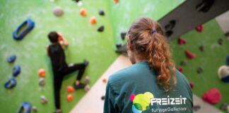 Deborah Berndt, Projektmitarbeiterin von Exil e.V., beobachtet ein Kind beim Klettern – das Projekt „FreiZeit für junge Geflüchtete“ schenkt jungen Bewohner*innen der Erstaufnahme Bewegung, Begegnung und Selbstvertrauen. / Foto: Nds. Lotto-Sport-Stiftung/Johannes Krüger
