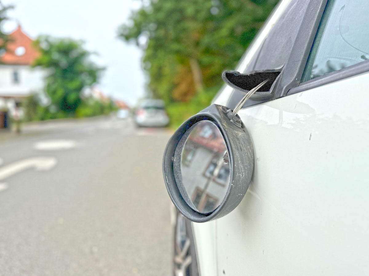 Abgetretener Spiegel an einem Auto im Süberweg
