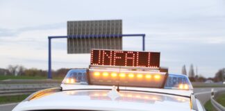 Streifenwagen der Polizei mit gelbem Warnlicht und Text "Unfall"