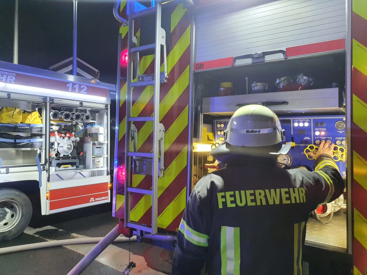 Maschinist einer Feuerwehr bedient Pumpe an einem von zwei Feuerwehrfahrzeugen. / Foto: Heiko Westermann