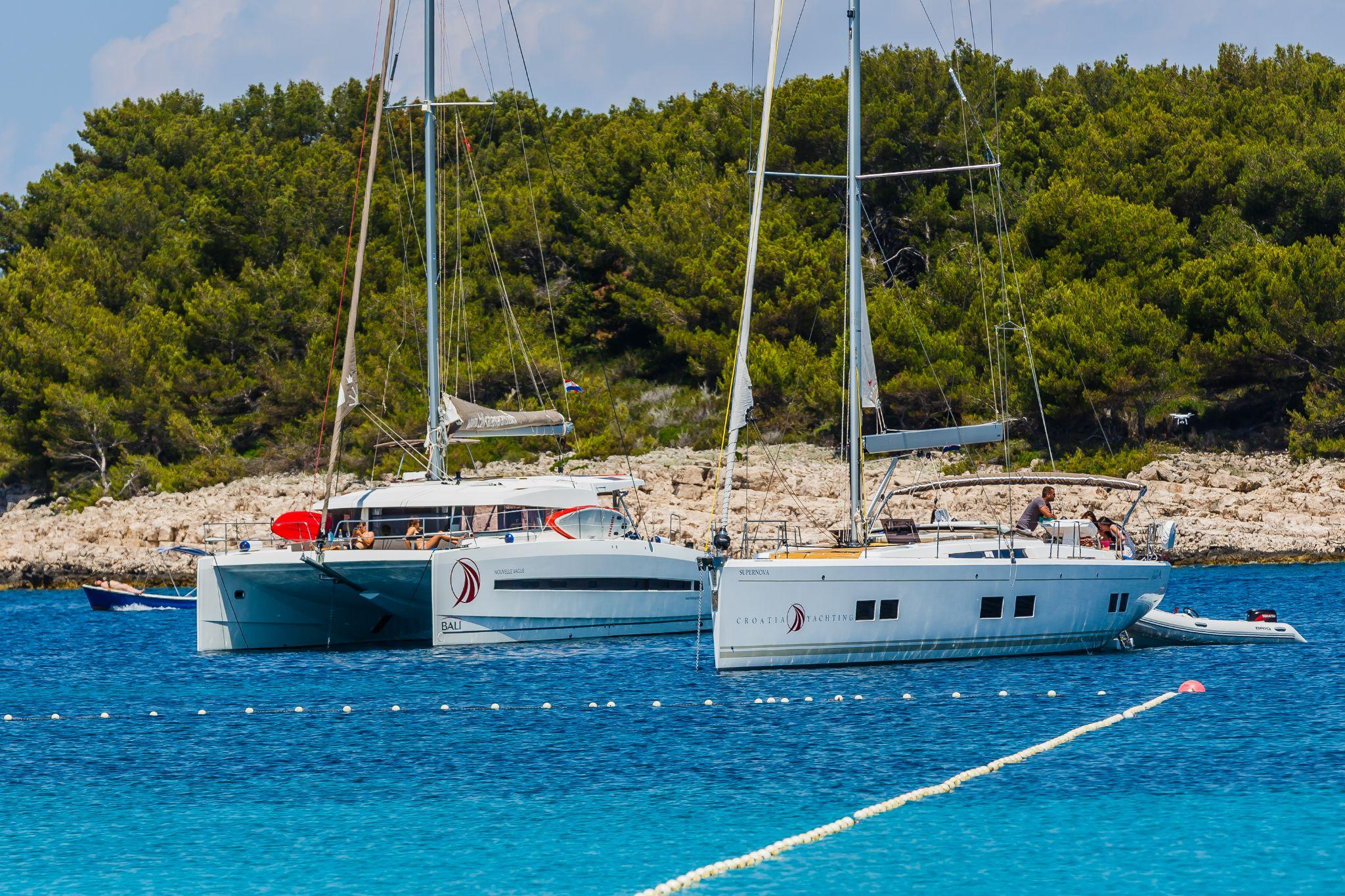 Katamaran und Segelyacht vor Anker