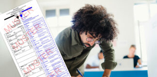 Mann gibt seine Stimme im Wahllokal ab / unsplash+ Getty Images