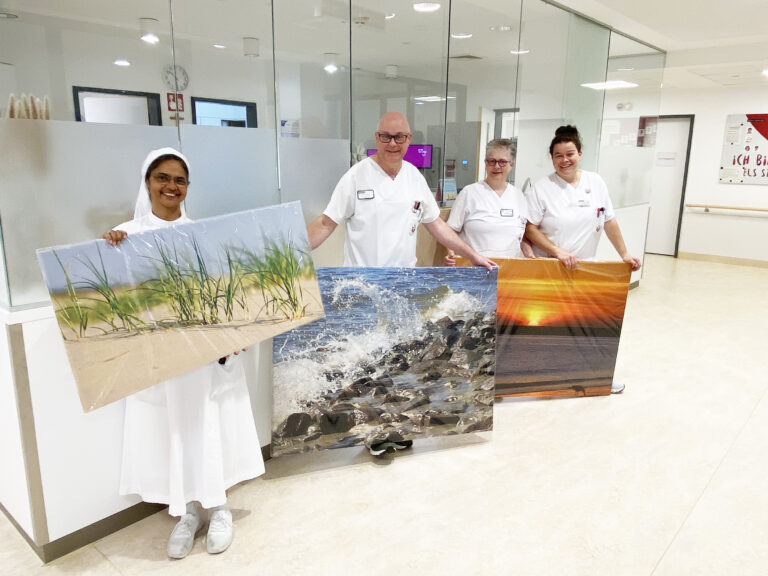 Über die neuen Bilder auf der Station 3a in den Niels-Stensen-Kliniken Bramsche freuen sich (von links) Schwester M. Della Jacob, Christian Droste, Simone Bogner und Iris Fänger (Stationsleitung). / Foto: NSK
