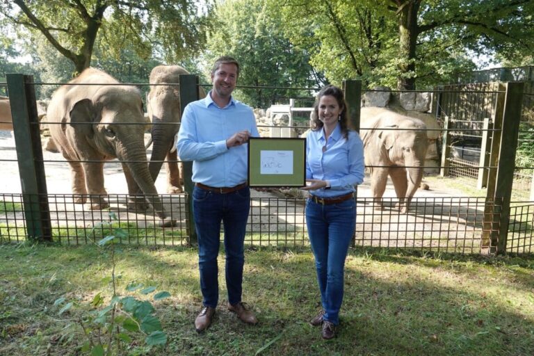 Philipp Bruelheide (Zoogeschäftsführer) und Larissa Langkamp (Sponsoring und Fundraising Zoo Osnabrück) freuen sich über das exklusive Werk von Otto Waalkes und warten gespannt auf das Ergebnis der stillen Auktion.